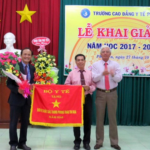 Phó Bí thư thường trực Tỉnh ủy Lương Minh Sơn trao cờ thi đua xuất sắc cho lãnh đạo nhà trường - Ảnh: MẠNH THÚY