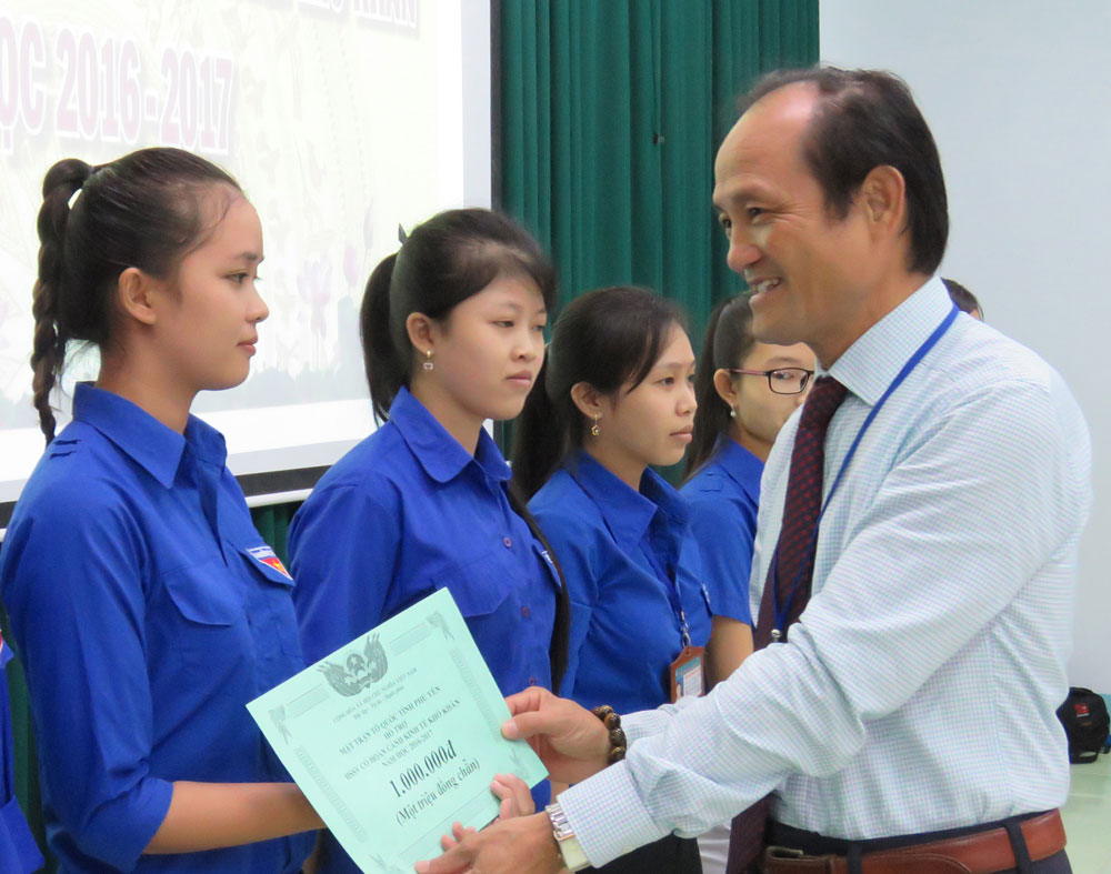 Hiệu trưởng Trường cao đẳng Y tế Phú Yên Bùi Trần Ngọc trao tiền hỗ trợ chi phí học tập cho học sinh, sinh viên - Ảnh: THÚY HẰNG