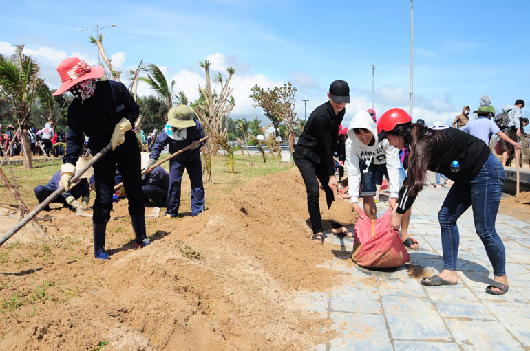 Sinh viên Trường cao đẳng Y tế Phú Yên làm vệ sinh, nạo vét cát tại khu vực đi bộ đường Độc Lập sau cơn bão số 12 - Ảnh: TRUNG HIẾU